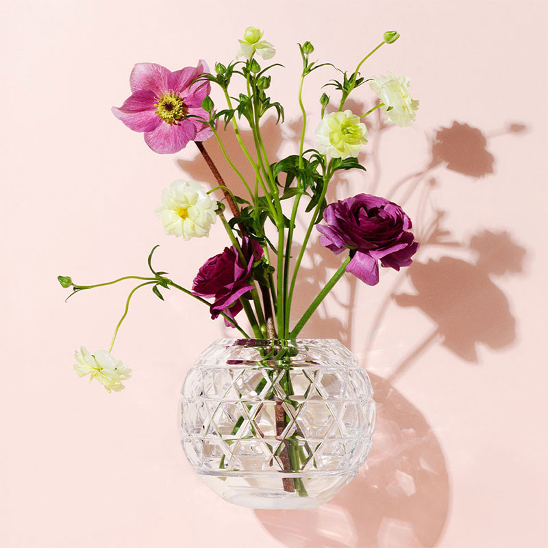 Vase décoratif contenant des fleurs posé sur une surface claire